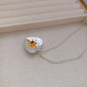 Elegant two-tone heart necklace with white pearl inlay and star red gemstone pendant