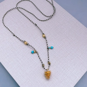 Handmade woven rope necklace with gold pinecone pendant and turquoise accent beads