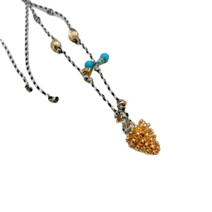 Handmade woven rope necklace featuring a gold pinecone pendant and turquoise beads