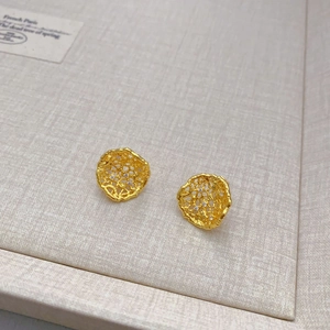 Boucles d'oreilles dorées en maille creuse avec zircons présentées sous un angle de 45 degrés