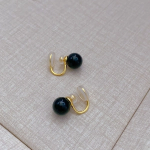 Detail of black agate clip-on earring with gold-plated U-shaped clip and silicone pad