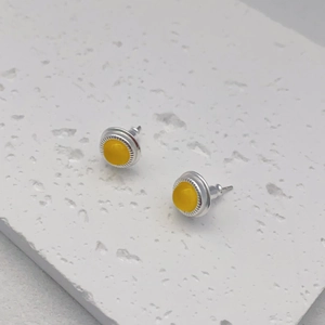 Silver stud earrings with round yellow agate stone inlay and textured gear edge design