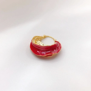 Close-up of red enamel earring with 18K gold plating and inner lava texture detail