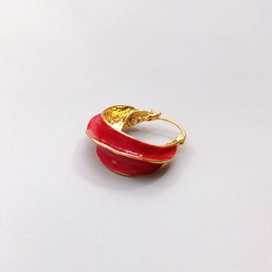 Macro detail of red enamel earring with textured 18K gold-plated interior and petal shape