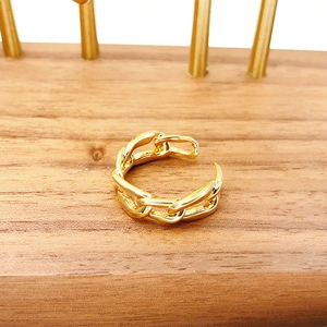 Eleganter vergoldeter Panzerketten-Ring offen auf einem Schmuckständer aus Holz