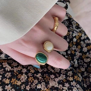 Retro gold open ring set featuring green malachite and cream stones on model's hand
