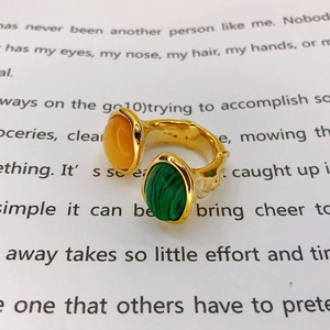 Macro shot of a vintage gold open ring featuring oval yellow and green malachite stones