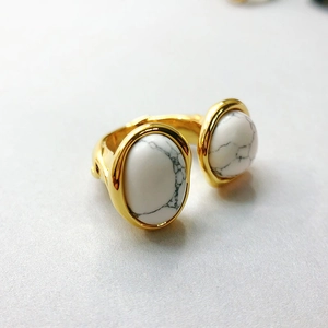 Detailed macro view of retro open ring with dual white marble stones and gold plating