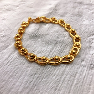 Nahaufnahme des 18K vergoldeten Gliederarmbands mit Metallperlen und Karabinerverschluss