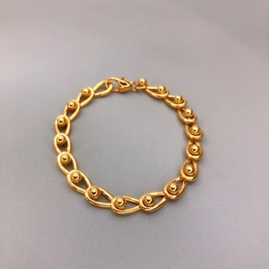 Makro-Detail von 18K vergoldetem Tropfen-Armband mit polierten Kugelgliedern