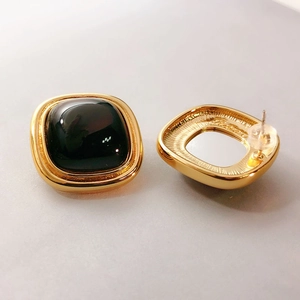 Macro shot of 18K gold plated square stud earring showing front gem and back details