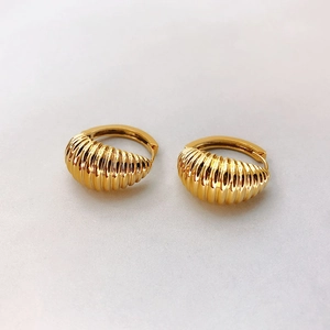 Détail des boucles d'oreilles croissant plaquées or avec texture nervurée vintage chic