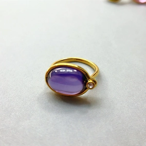 Makroaufnahme: 18K vergoldeter Ring mit ovalem violettem Edelstein und Zirkonia-Akzenten