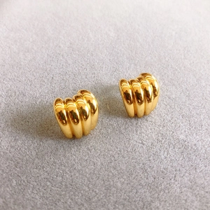 Macro shot of 18K gold plated ribbed stud earrings showing high-polish texture