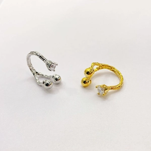 Detail of gold and silver irregular textured rings with sparkling zircon inlay