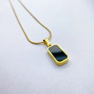 Minimalist gold necklace featuring a sleek rectangular black shell pendant on a thin chain