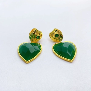 Detail of heart-shaped emerald green drop earrings with textured 18K gold plating
