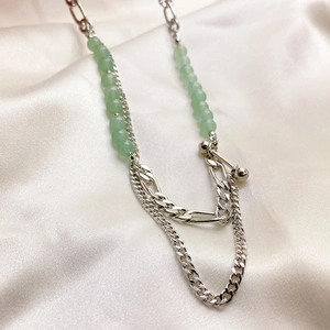 Modern rhodium-plated chain necklace with green aventurine beads on white silk background
