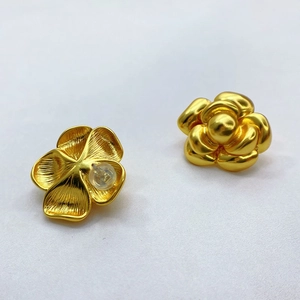 Detail von 3D-geschnitzten Gold-Kamelien-Ohrsteckern mit gebürsteter Textur und Silikonstopfen