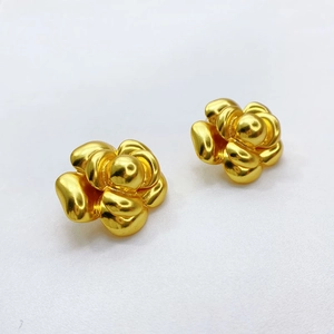 Detaillierte Makroansicht der 3D-geschichteten goldenen Kamelien-Ohrringe mit sanftem Glanz