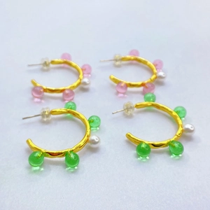 Détail de boucles d'oreilles C dorées 18K avec perles colorées et perles blanches