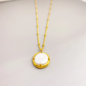 Collier pendentif perle baroque en acier inoxydable doré sur fond gris minimaliste
