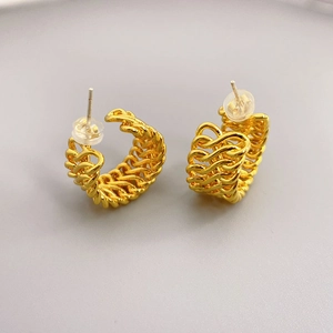 Retro hollow braided C-shape hoop earrings with 18K gold plating on a grey surface