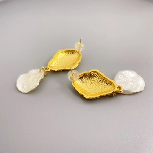 Golden 18K plated baroque pearl earrings with irregular hammered texture on gray backdrop