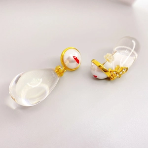 Teardrop pendant earrings with pearl and red lip pattern in a stylish gold setting