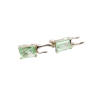 Silver fluid metal stud earrings with emerald-cut green crystal stones in a modern design