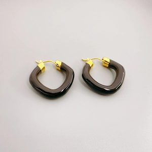 Detail of irregular translucent brown resin hoop earrings with 18K gold-plated clasp
