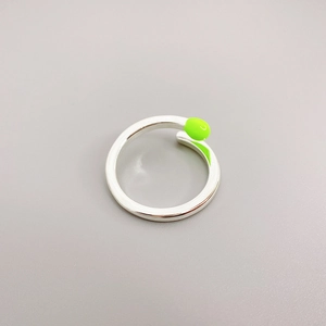 Unique silver matchstick open ring featuring vibrant green enamel detailing on a gray background