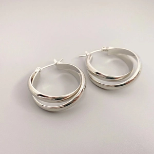 Macro view of interlocking silver double-hoop earrings with high-polish metal finish