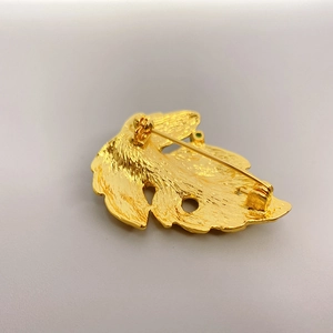 Back view of gold leaf brooch featuring brushed metal texture and a secure pin clasp