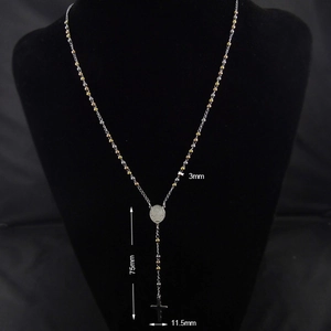 Detailed view of two-tone rosary necklace with 3mm beads and cross pendant on black display