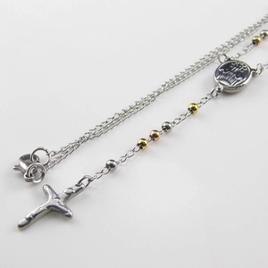 Macro view of stainless steel rosary necklace with polished beads and cross pendant