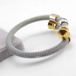 Macro detail of three-tone twisted cable bracelet with gold and rose gold tapered ends