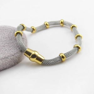 Detail of silver mesh bracelet with golden decorative beads and magnetic cylinder clasp