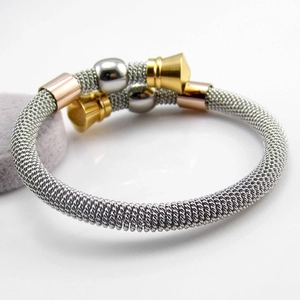 Detailed macro view of woven twisted titanium steel cable bracelet with tricolor accents