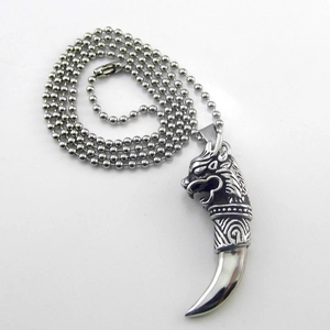 Detail of silver wolf tooth pendant with ball chain in gothic stainless steel style