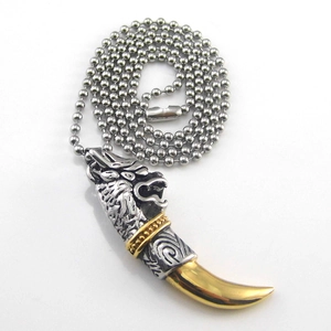 Detail of a two-tone wolf tooth pendant with vintage engraving and steel ball chain