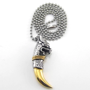 Detail of vintage wolf head pendant with golden tooth accent on steel bead chain