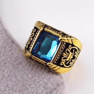 Macro shot of men's vintage gold ring with rectangular blue stone and black enamel