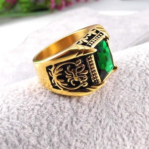 Detailed macro view of vintage gold ring with emerald cut green stone and enamel