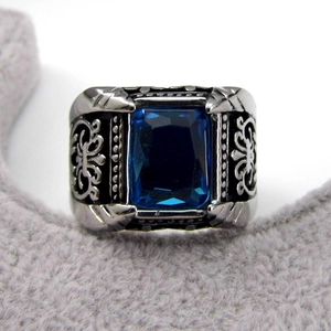 Detail of vintage men's ring with rectangle blue gemstone and ornate silver carving