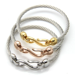 Detailed set of three stainless steel cable bracelets in gold, rose gold, and silver finishes