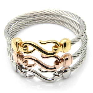 Close-up of three-tone steel cable bracelets in gold, rose gold, and silver finishes