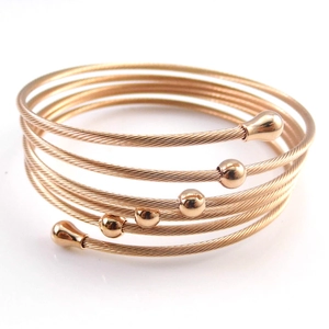 Detailed macro view of multi-layer rose gold cable bracelet with metallic beads