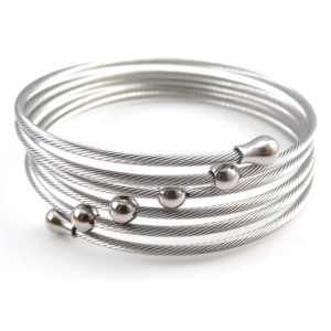Close-up of silver multilayer spiral steel wire bracelet with metal beads and water drop ends