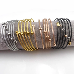 Detail of multi-layer stainless steel wire bangles in silver, gold, rose gold and black